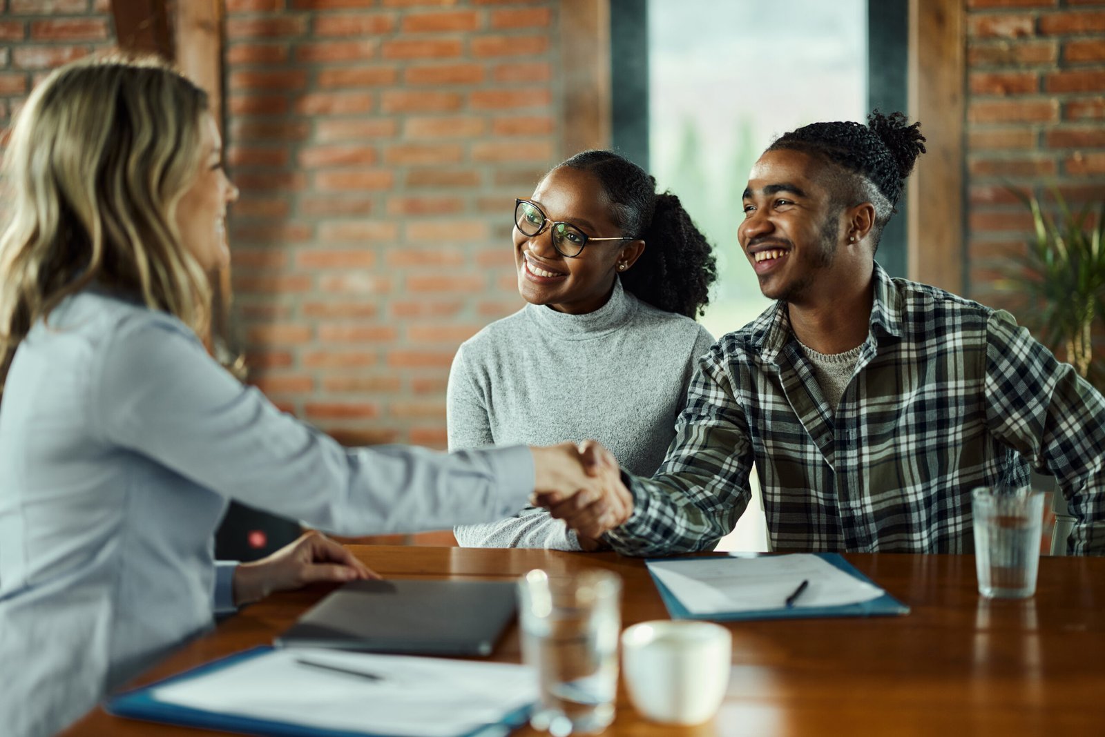 Happy female agent came to an agreement with her customers in the office. Happy female agent came to an agreement with her customers in the office.